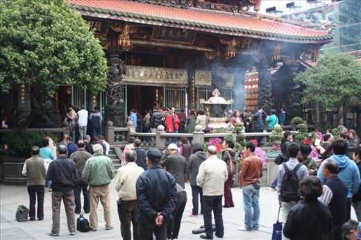 People facing the main altar of Longshan Temple during a service