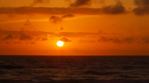 A newly emerging sun combined with winds  blowing smoke southerly, from a bush f