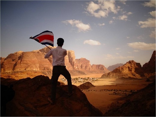 Feeling the honor and freedom of waving the flag of his people above a land. 
