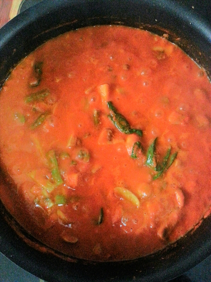 The tomato-based sauce cooking with vegetables