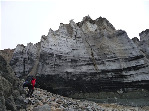 A climber in awe of the massive face of a glacier en route to camp 1.