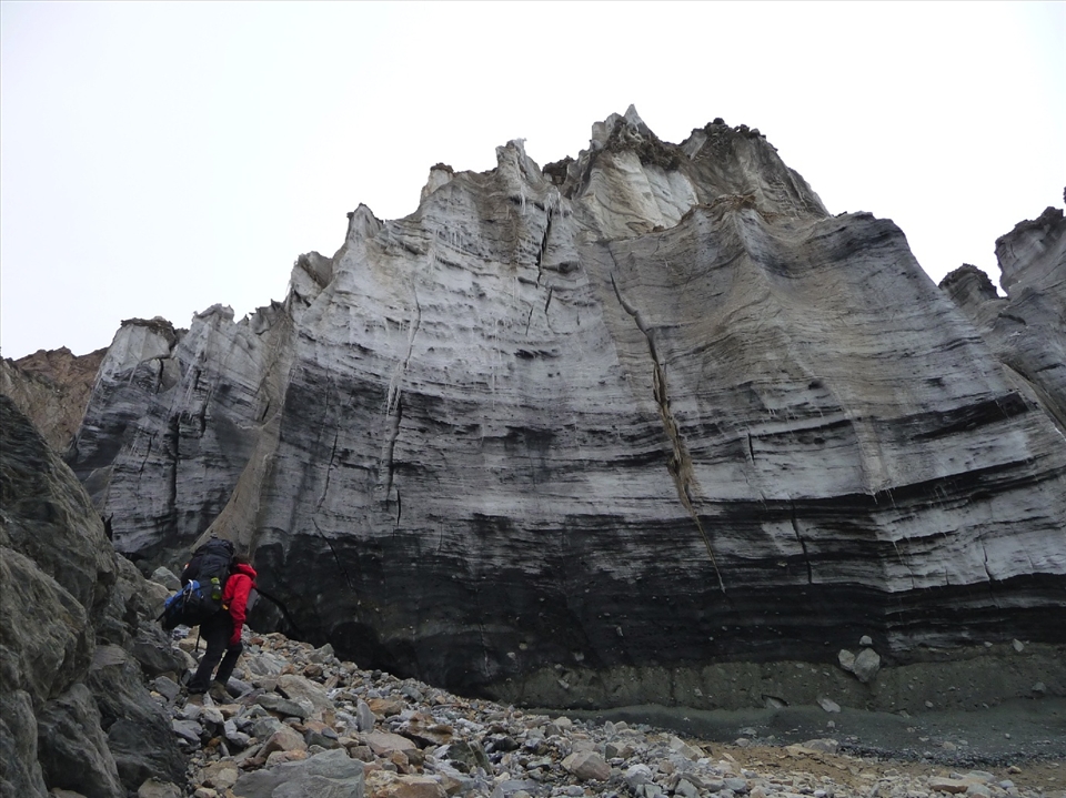 A climber in awe of the massive face of a glacier en route to camp 1.