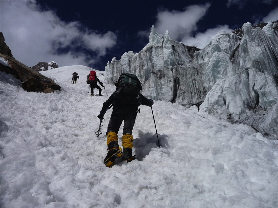 Climbers pass a cathedral-like landscape of ice and snow.