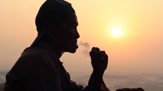Setumbu Hill sunrise, old man smoking traditional corn leaf javanese cigarette