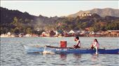 Nearing the end of a long day, locals are seen aboard their boat. They use a 
long bamboo stick to turn the rudder. A portion of the town of Coron and the 
sign on the hilltop are seen in the distance.: by paolonacpil, Views[260]
