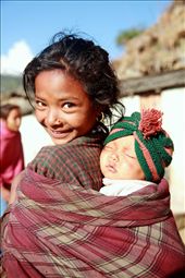 Smile of the innocent - A young girl shows her new-born sister in Jyare village of Mugu district in Nepal with a warm and welcoming smile. She is the care-taker of her sister as her mother goes to work in the field.: by pari, Views[813]