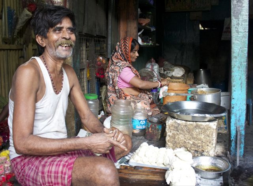A man and woman prepare breakfast for fellow stall workers. 