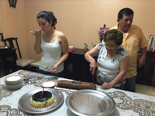 Señora Olinda cutting one of her many cakes with Daniella and Humberto