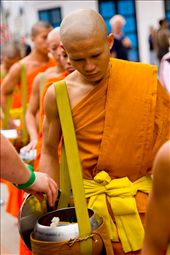 A monk accepts a humble token of rice grains from a tourist in Laos.: by paulfilm, Views[500]