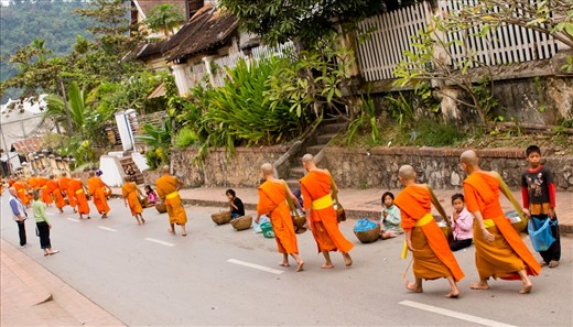 Everyday, a procession of Laotian Buddhist monks visits the surrounding township to collect food from the locals.