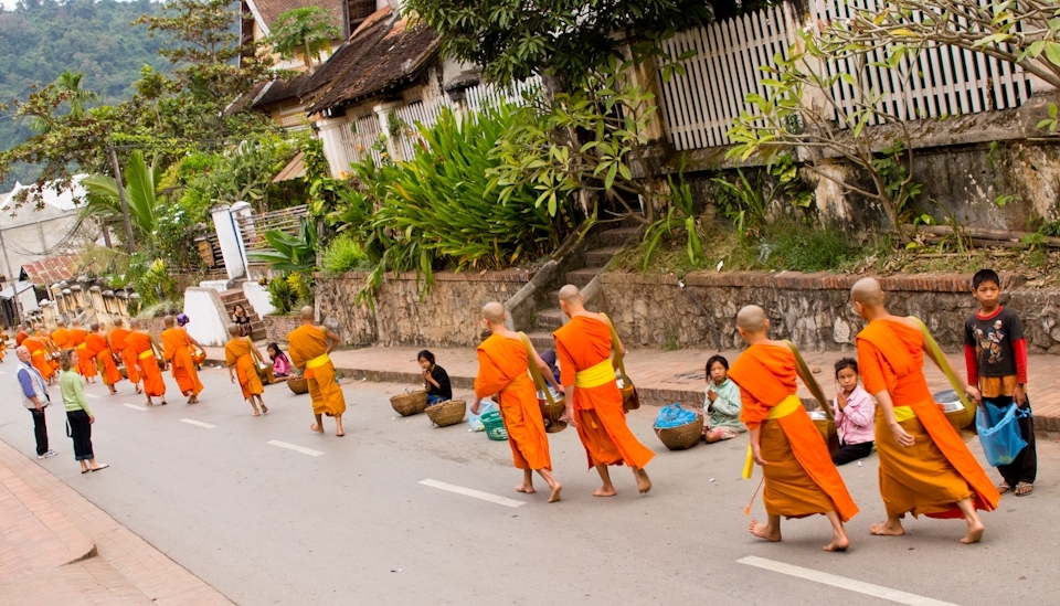 Everyday, a procession of Laotian Buddhist monks visits the surrounding township to collect food from the locals.