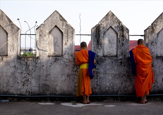 Two young monk novices look over the surrounding township – a world they have left behind for a life of quiet sobriety. 