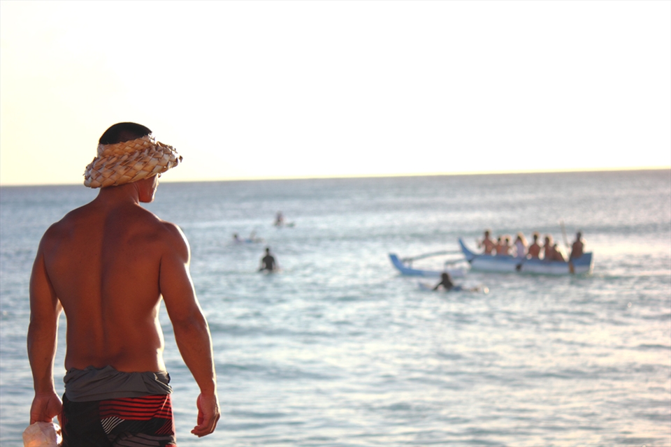 Catamaran host scouts out the waters that lay before a sunset cruise.