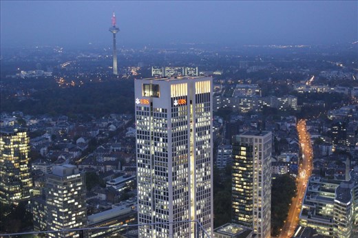The modern side of Germany shown through a newer skyscraper Opernturm, Frankfurt. The small details play the role here, the television tower showing the development since 1970s and empty road in comparison with full offices suggest a hard-work of Germans on Monday evening.