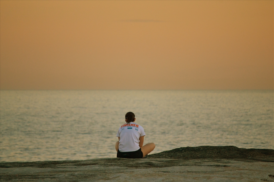 A woman taking in a sunset after she finished her run.
