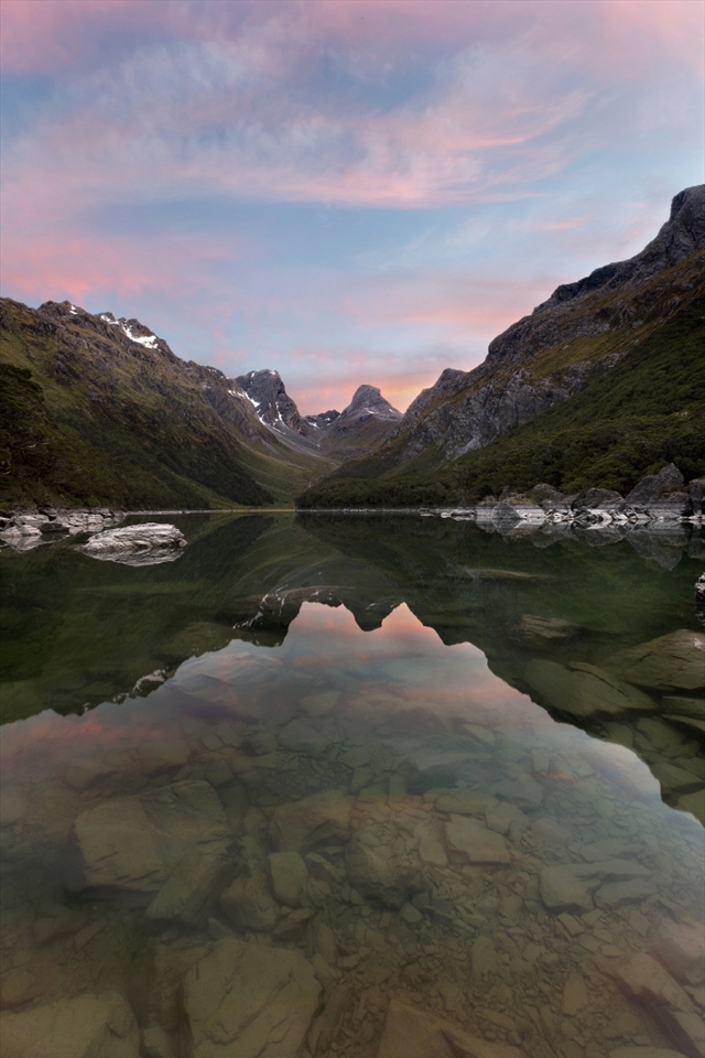 Lake McKenzie at Dawn:
This picturesque lake is a reward on the Routeburn Track, a 32km track in New Zealand’s South Island that weaves through the valleys and lakes of the Southern Alps.