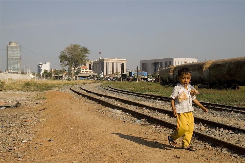 Phom Penh, Cambodia: Small children trudge their way into the city where they see how rich people live and to beg for money or sell goods so they can help contribute to their struggling families. After a long day this child wearily makes his way home with his days earning of 2 bags of nuts.