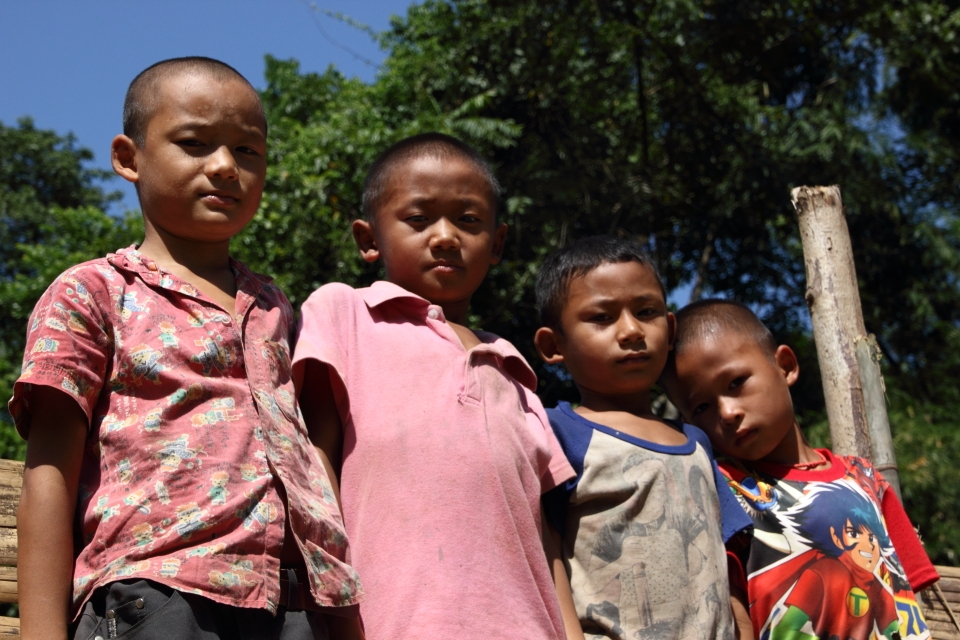 After taking a few shots of these children I went down to the river interested in taking the beautiful mountains and river I noticed most of the village kids behind me were following me they wanted to see my camera and wanted more photos. I took the opportunity to get to know the kids and let them play with my camera and taking photos with my instructions on how to use the camera and taking pictures, it was great fun.

Taken at Mae Saut Noi  village in  Mae Sariang - Mae Sot area in Thailand, the people are of the Karen tribe they are one of the many ethnic groups from Burma and have moved from their villages from Burma escaping the civil war conflict against them by the Burmese Military or extreme poverty their life's are much more free in Thailand than in Burma where it's very dangerous over their. 

This is one of the very few villages that are still very traditional way of living very simple life, they have no electricity or technology but they are happy living like this in their cozy bamboo huts. The kids play outside all day everyone cheeps in like washing clothes, cooking ect. The environment/hygiene isn't that clean as they are quite poor. It was a great and very nice atmosphere something that I have never experience before.

I captured mainly children in this rural village they were very excited seeing a foreigner and were most interested in my big slr camera as I was clicking away. 
