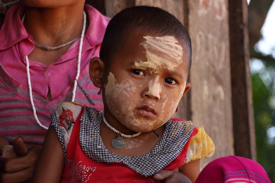 This little girl is wearing Thanaka on her face is a yellowish-white cosmetic paste made from ground bark. It is a distinctive feature of Myanmar (formerly Burma) seen commonly applied to the face and sometimes the arms of women and girls. It protects them from the harsh sun and helps moisturise their skin. 


Taken at Mae Saut Noi  village in  Mae Sariang - Mae Sot area in Thailand, the people are of the Karen tribe they are one of the many ethnic groups from Burma and have moved from their villages from Burma escaping the civil war conflict against them by the Burmese Military or extreme poverty their life's are much more free in Thailand than in Burma where it's very dangerous over their. 

This is one of the very few villages that are still very traditional way of living very simple life, they have no electricity or technology but they are happy living like this in their cozy bamboo huts. The kids play outside all day everyone cheeps in like washing clothes, cooking ect. The environment/hygiene isn't that clean as they are quite poor. It was a great and very nice atmosphere something that I have never experience before.

I captured mainly children in this rural village they were very excited seeing a foreigner and were most interested in my big slr camera as I was clicking away. 