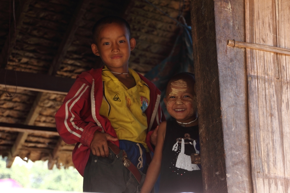 This was taken in one of the many traditional bamboo huts on stilts. These kids were in their home and i waved at them and smiled to ask them their photo they giggled especially the younger child on the right when I took their photo. They don't see any westerners or tourist in this rural country side of Thailand. None of them speak any English but I just weaved and they were more then happy to pose for me.


Taken at Mae Saut Noi  village in  Mae Sariang - Mae Sot area in Thailand, the people are of the Karen tribe they are one of the many ethnic groups from Burma and have moved from their villages from Burma escaping the civil war conflict against them by the Burmese Military or extreme poverty their life's are much more free in Thailand than in Burma where it's very dangerous over their. 

This is one of the very few villages that are still very traditional way of living very simple life, they have no electricity or technology but they are happy living like this in their cozy bamboo huts. The kids play outside all day everyone cheeps in like washing clothes, cooking ect. The environment/hygiene isn't that clean as they are quite poor. It was a great and very nice atmosphere something that I have never experience before.

I captured mainly children in this rural village they were very excited seeing a foreigner and were most interested in my big slr camera as I was clicking away. 
