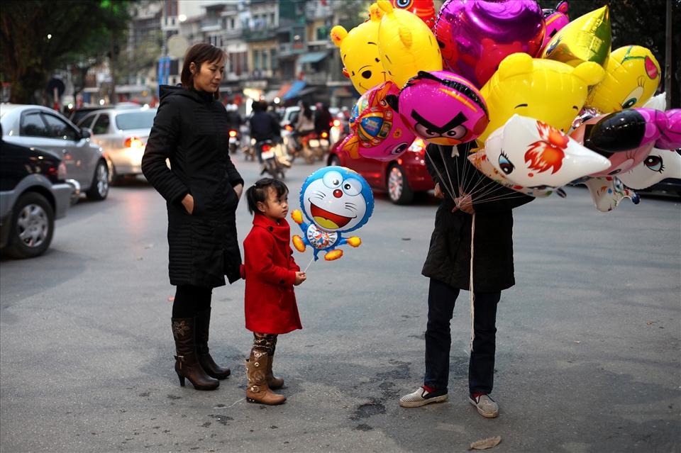 A woman buys her daughter a balloon for 