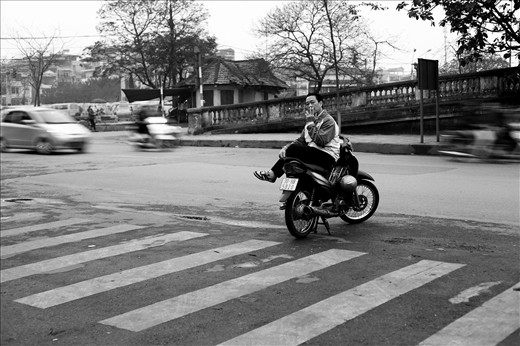 A man has a cigarette break in the middle of an intersection.