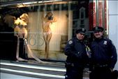 New York, United States of America, two policemen posing and holding a British boy band miniature figure in front of a provocative Victoria's Secret lingerie store window in the center of business and fashion. We live in a plastic world where looks and bank balances determine your value to the society. People are obsessed with fame and celebrities, even the police are there to entertain. Media and businesses create global trends and unrealistic expectations and try to capitalize with them in every turn, anything goes when it comes to marketing. We are slaves of market forces.: by photographeronprogress, Views[556]