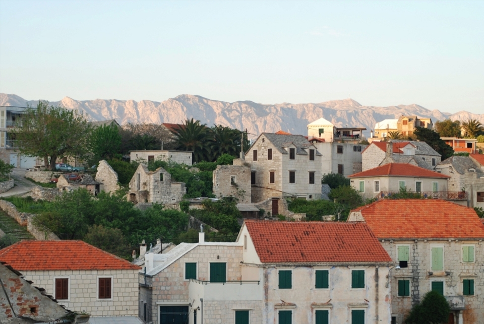 Illuminated hills beyond the village of Sumartin, Island Brač. The houses are build in the traditional dalmatian style. The village looks like the time has stopped.