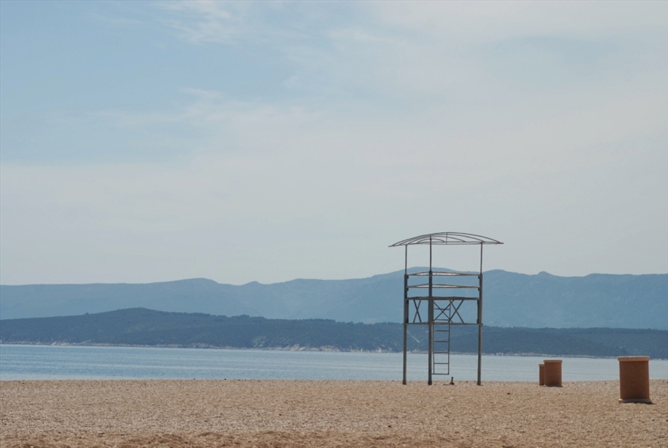 The lifeguard stand and trash bins are waiting for the crowds to roll in.