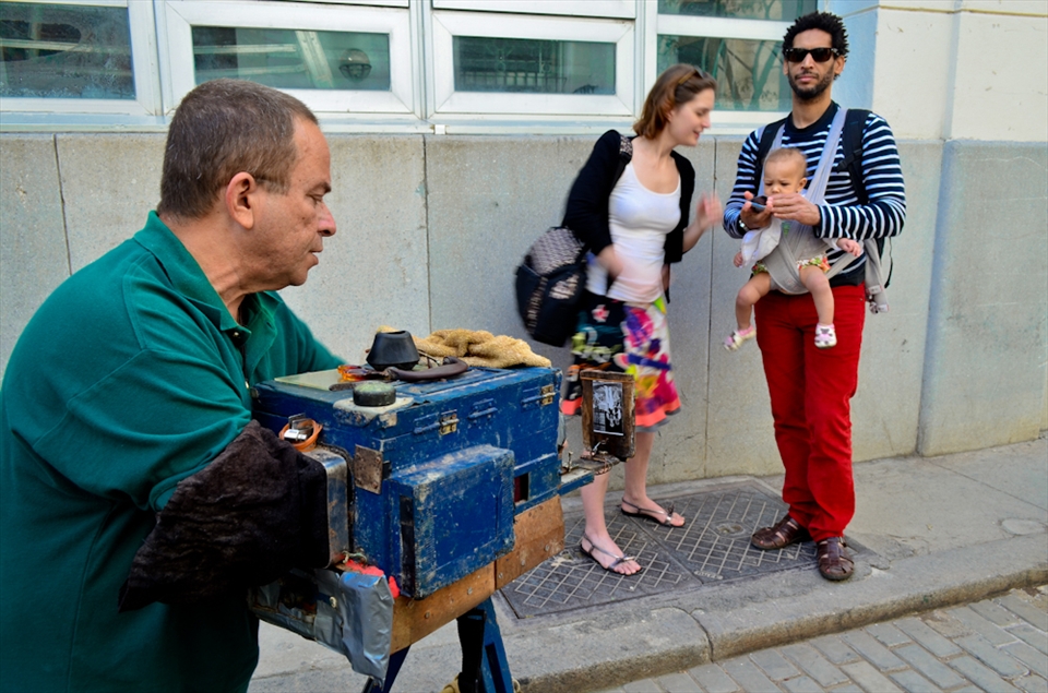 Dealing between the novelty and the ancient, the “150 years” camera with its sickly and geary sound, whose owner is the well known “Albert, the camera man”, keeps photographing walkers in “La Habana Vieja” (Habana’s Old District) after four generations of usage. “My grand- grand father built it from nothing, with the fresh enthusiasm of a self-taught scientist and the sadly creativity of a man who grew up in the Cuban poverty way. I learned from my grandfather, I remember him telling me since I was a 7 year old: take a photo and ask for a tip, ask for a tip”. Alberto has two sons of 16 and 18 years, none of them wants to learn from his dad how to use the “150 years” camera; one wants to become a doctor and the other a cosmonaut, they want to make money, he exclaims. “I can’t force them to do anything related to this camera; they don’t want to become photographers, my craft is despised by them because it is not modern, after I die this camera will die also”.      