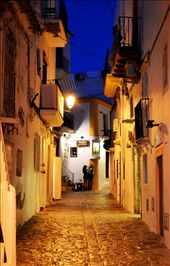 Ibiza, what an island! Beauty & party is supreme in the streets of this exotic island. My group of friends & I decided to go roam the streets in order to find something to eat as the sun was going down & we would have to go back to the ship soon. The streets weir really crowded except for this one! The reflection of the yellow lights on the floor & woman closing shop & removing her mannequin, what a sight.  Again Serenity was my theme.  Thanks for following me trough my journey.: by picturevibes, Views[283]