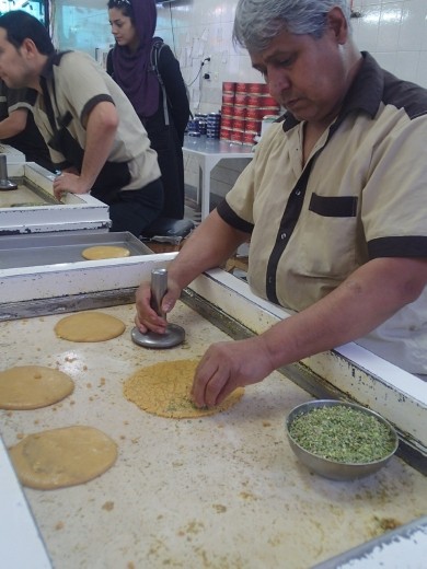 Iran - Qom - sprinkling the chopped pistachios on the dough
