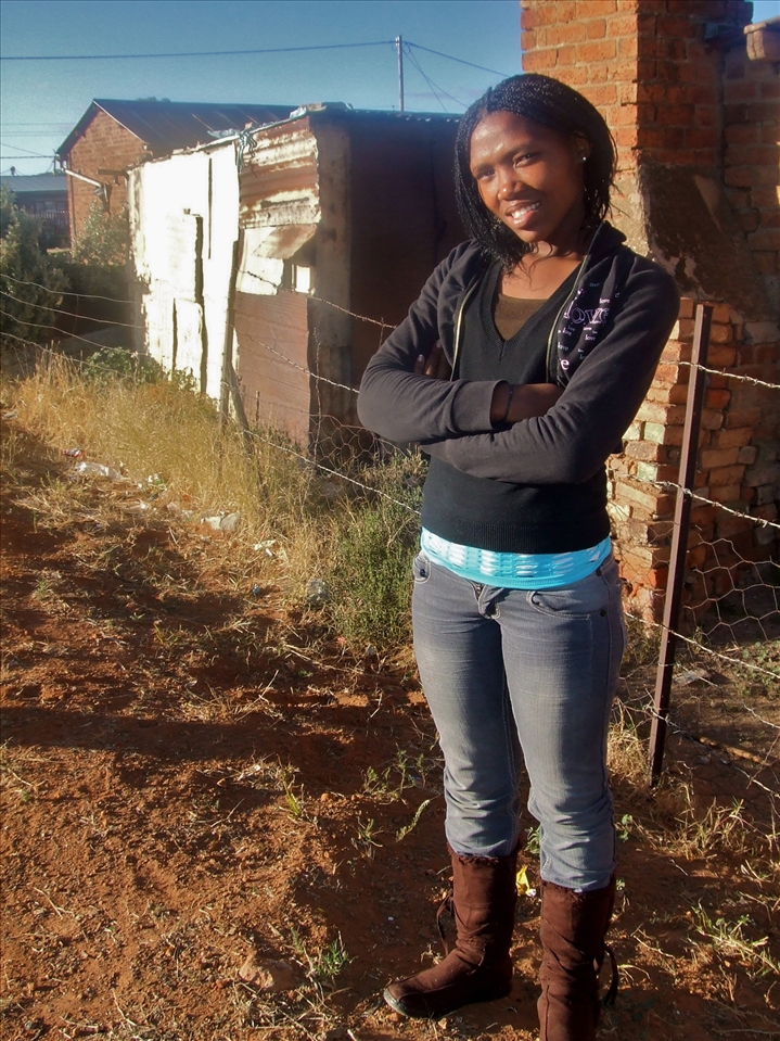 Kholiwe stands among the ground she grew up on, though not the same person. She has determination and confidence, dreams of becoming a singer. Though the place she has called home is being taken away, she stands as a leader among the other children and faces the future with hope. 