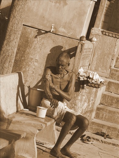 a poor old man was taking bath in open backyard of fort