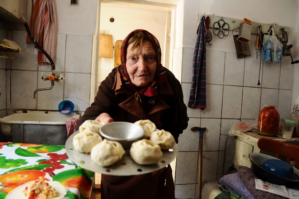 My grandmother lives in Kyrgyzstan, Central Asia. Life here reverts back to the Soviet era. In this photo my grandmother is offering steamed dumplings on my last day there, she was emotional, nervous, sad and yet eager to please. Everything is made by hand, and there is no such thing as an electric mixer in my grandmothers’ world. In fact almost all the equipment she owns dates back 15 or 30 years. This is a place where wires hang exposed from walls, washing machines are like gods - and are even given rest breaks ( meaning we revert to hand washing) to ensure that the washing machine doesn’t over work. My grandmother somehow turns into a comedian when I bring western travelers to their place to stay, she becomes the charismatic centre of attention as she sits in her kitchen happily questioning and joking with a room full of young travelers.