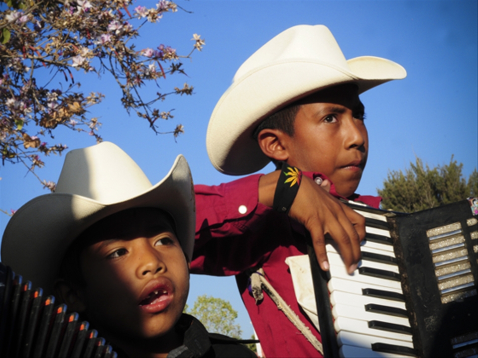 Two brothers playing in a plaza on a sunday, one sang the other accordion. 