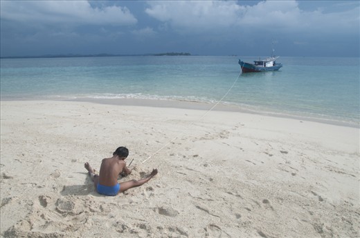 a child trying to hold the boat anchor  when docked at the beach