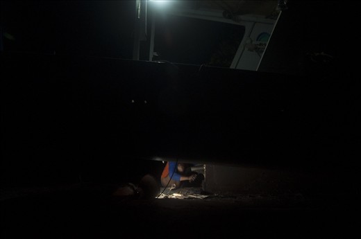 a man repair ship propeller at night when low tide