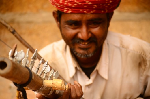 Man playing traditional musical instrument to entertain people.