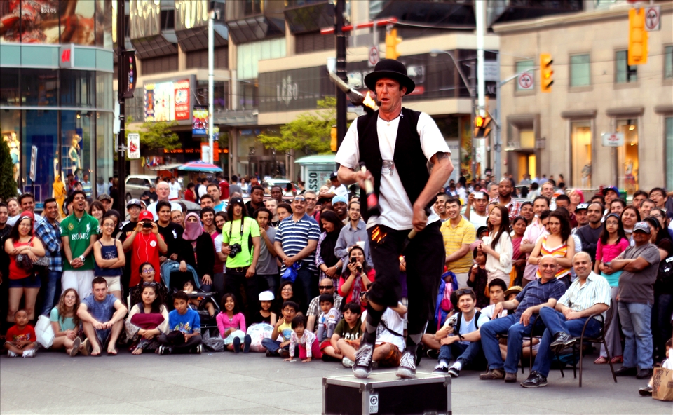 A street performer brings joy to people of all age, sex and color.