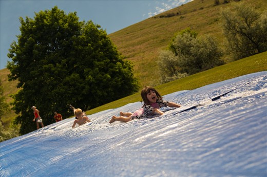 (2) Even though there are over 60,000 residents, Missoula retains a “small-town” feel. The pace of life can be as fast or as slow as one chooses it to be.  Neighborhood children shown above slip-and-slide down a hill during a community barbeque open to all.  Here, there is no right or wrong way to enjoy oneself.