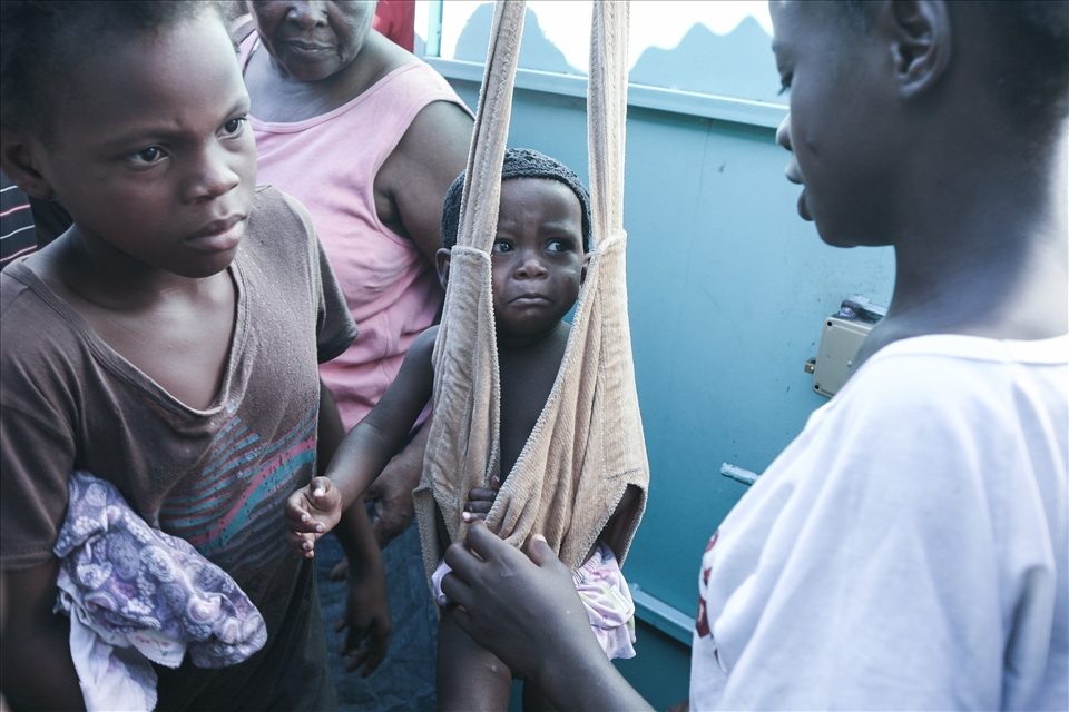 Children are weighed to monitor the effects of malnutrition