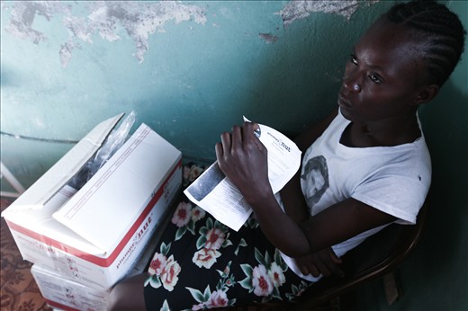 A concerned mother sits in front of Plumpy'Nut, a life-saving medical food
