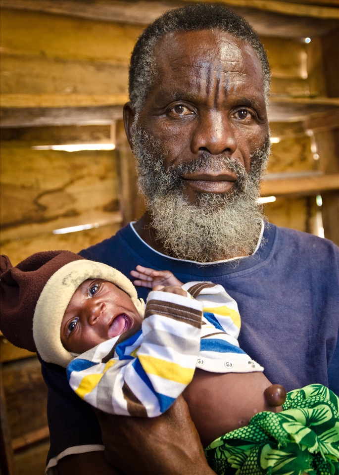 This man was in his final year of studying medicine before he had to leave his home in Angola because of the civil war. Despite having finished the training and exams he was never officially qualified. He and his wife now run a village for orphans. The baby girl in the photo and her twin sister were only 4 days old when this was taken. Their father died of AIDS and their mother died during childbirth.