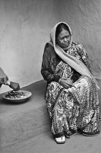 A slightly affluent sister of the village Headman, sitting in her house, with fire tray, on the chilly winter morning. Her family is educated and she understands the problem of the people, so she helps in mobilizing the people of the village to send their children to school.