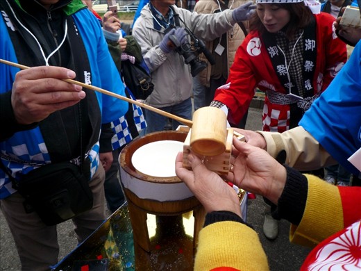 'Sake' rice wine is doled out to eager onlookers with traditional wooden implements and cups. Reverence of natural materials mirrors the respect for the natural forces that grow crops.