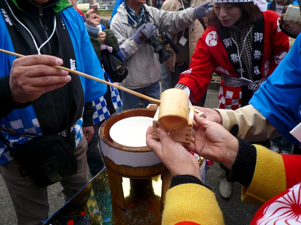'Sake' rice wine is doled out to eager onlookers with traditional wooden implements and cups. Reverence of natural materials mirrors the respect for the natural forces that grow crops.