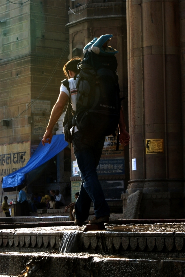 In quest of Peace:
A traveler walks along the ghats as beautiful light creates a  silver-lining. A lot of people travel to Varanasi in search of spirituality and inner quest.