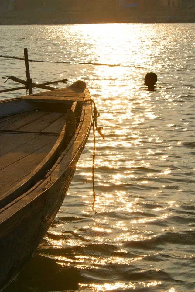 The adventurous holy dip:
A man shows adventurous spirit by swimming into the heart of Ganges and shows respect for the holy dip. 