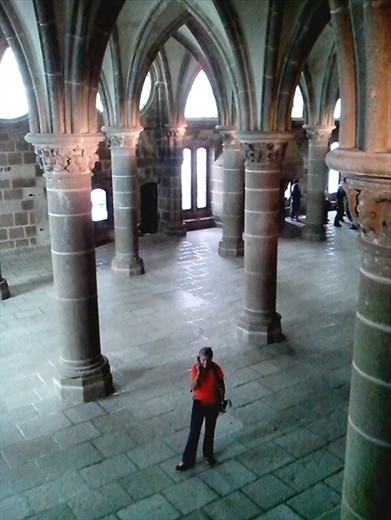 Janice standing in another crypt and listening to an English audio guide of the Abbey